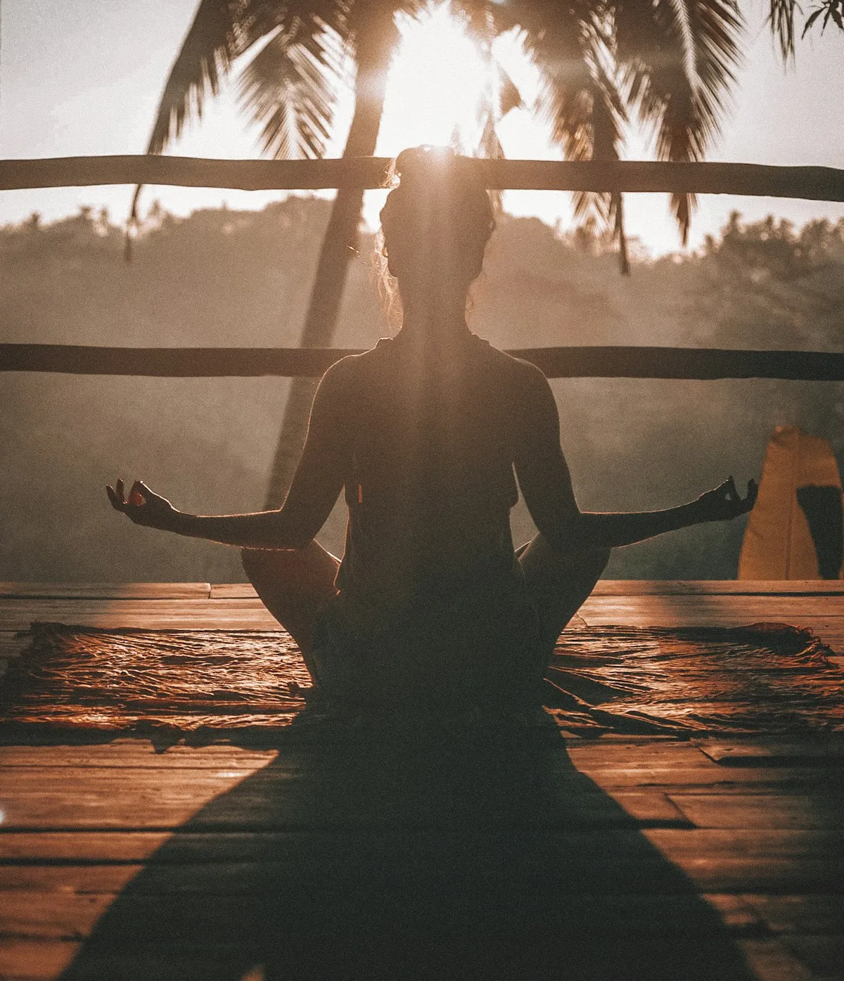 Des galets lisses posés sur un tapis de yoga près d’une tasse fumante, lumière tamisée.